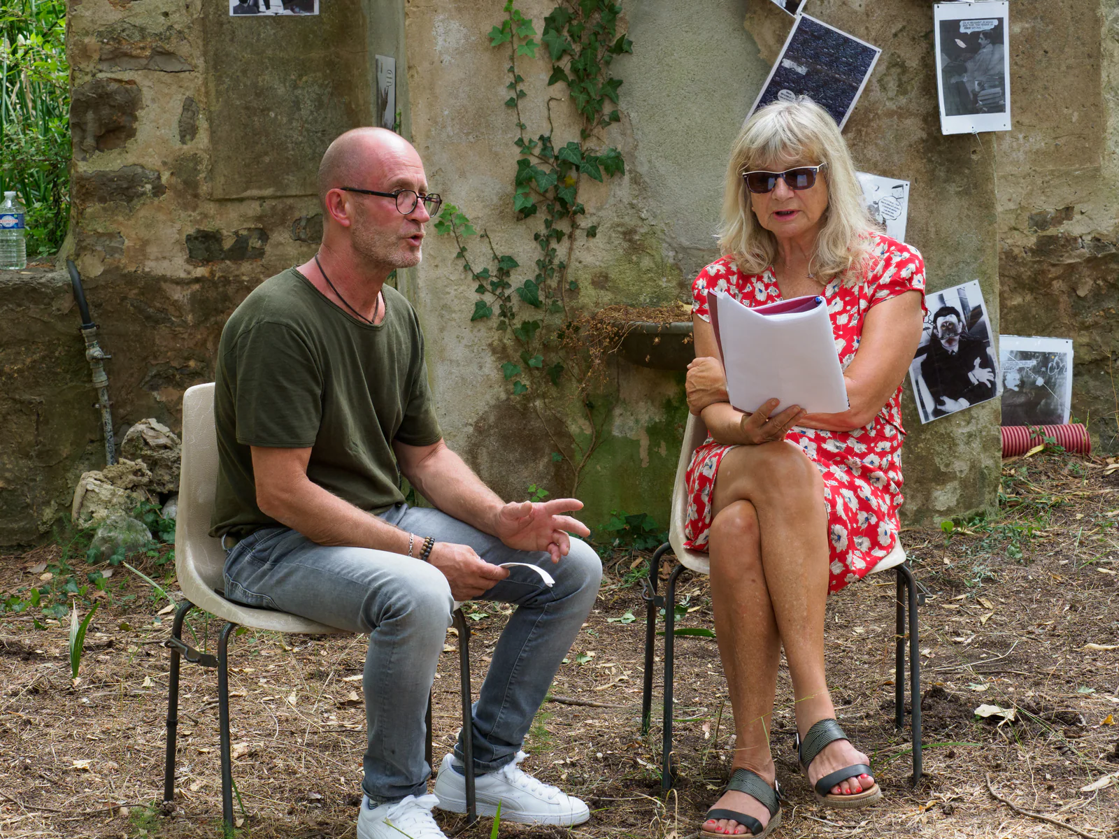 Deux interprètes assis pendant une lecture dans les jardins du Festival Confluences 2021