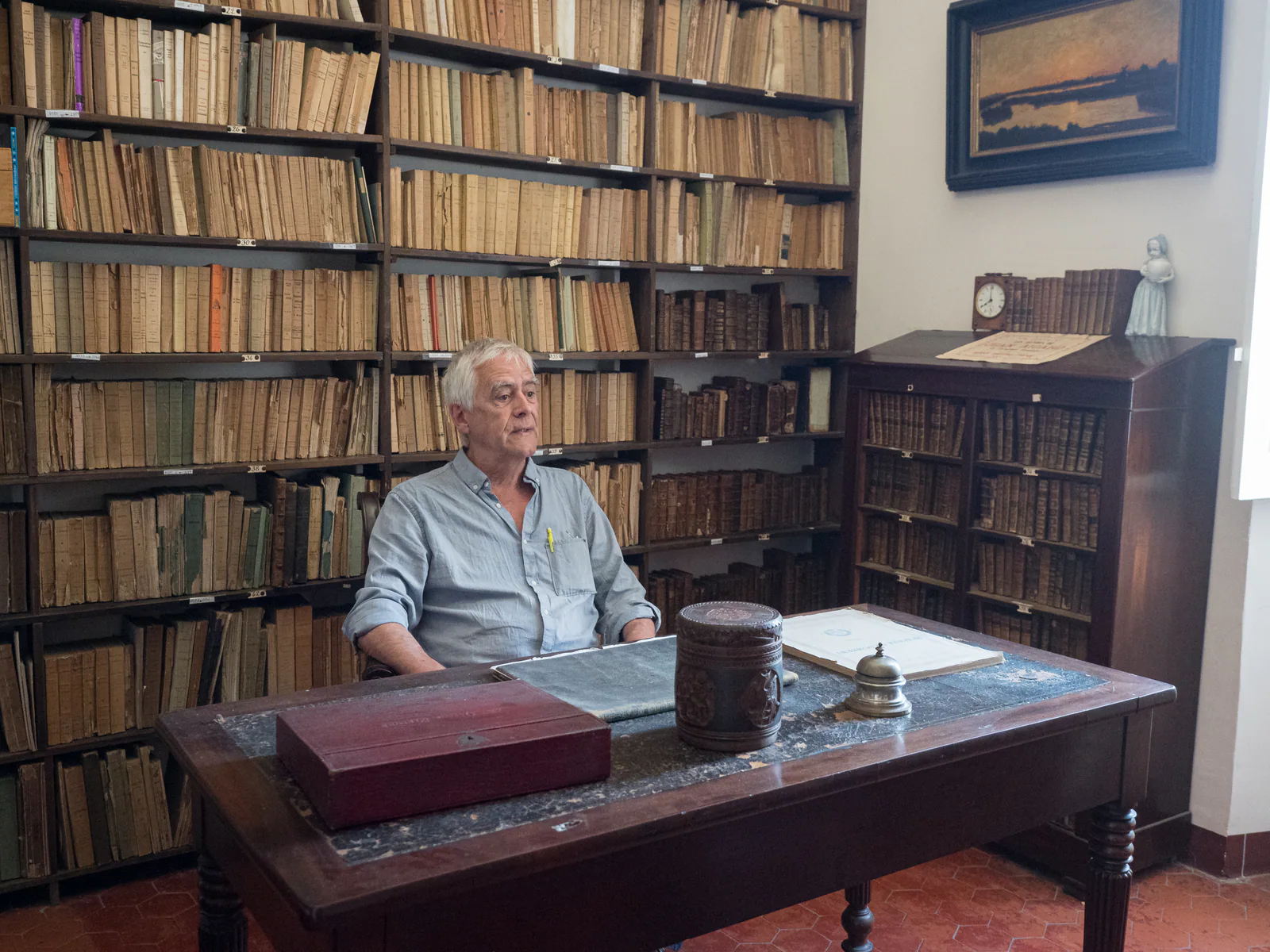 Jacques Jouet assis au bureau de Jean Aicard dans le musée