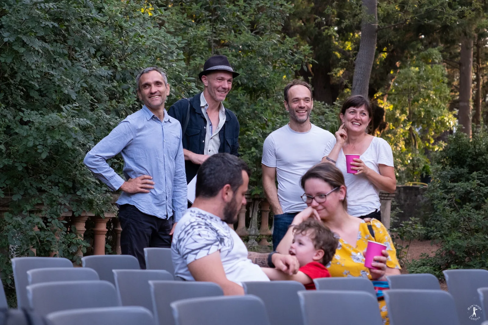 Artistes et public partageant un moment convivial dans les jardins