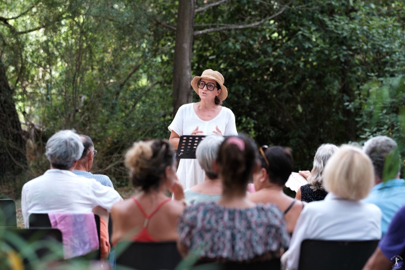 Une intervenante prend la parole devant le public réuni dans les jardins du Musée Jean Aicard