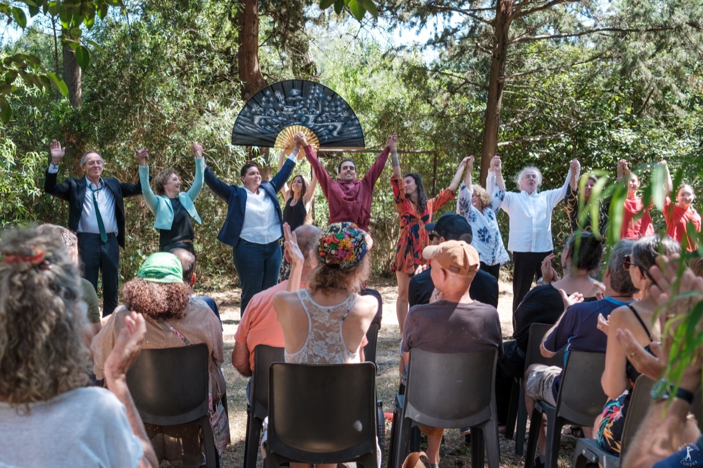 Une troupe d’interprètes salue le public après une représentation dans les jardins